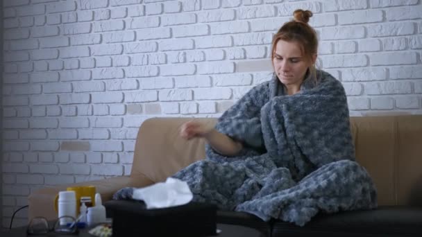 코카서스 여인은 소파에 느끼고 체온계를 사용하여 체온을 질병을 바이러스 초상화 — 비디오