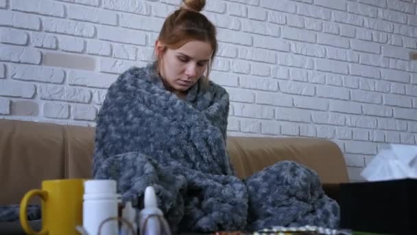 年轻的高加索女人坐在沙发上感觉不舒服 然后用温度计检查体温 病者病毒性病毒肖像 — 图库视频影像