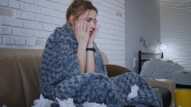 穿着灰色毯子坐在客厅沙发上的迷人的邪恶的高加索女孩 可爱的生病年轻女人的画像 可怕的偏头痛 感冒感冒感冒人感冒病毒过敏 — 图库视频影像
