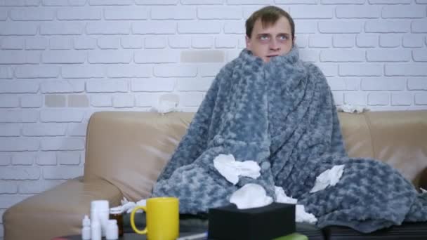 覆盖着灰蒙蒙的白种人 年轻的高加索人冻得在家里感到冷 生病的男性有发热的流感病毒 体温症状包裹在毛毯里 在室内发抖 — 图库视频影像