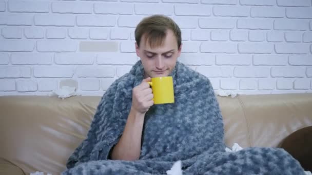 Chory Piękny Człowiek Przeziębieniami Pije Gorącą Herbatę Cytryną Siedząc Kanapie — Wideo stockowe