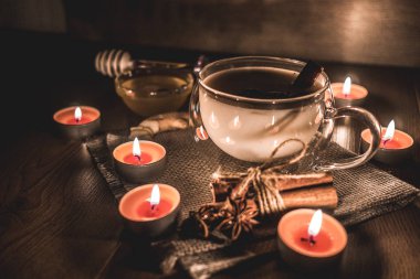 Mum ışığında yakılan geleneksel Hint masala çayı bardağı. Hint masala çayı - sade ahşap arka planda sütlü baharatlı çay, seçici odak, kopyalama alanı. Kapat.. 