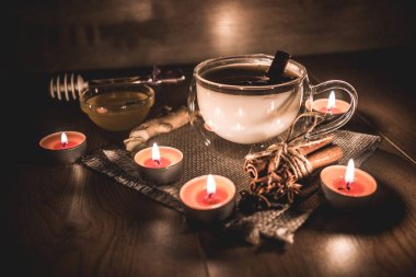 Mum ışığında yakılan geleneksel Hint masala çayı bardağı. Hint masala çayı - sade ahşap arka planda sütlü baharatlı çay, seçici odak, kopyalama alanı. Kapat.. 