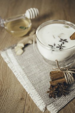 Bir bardak geleneksel Hint Masala Çayı. Hint masala çayı - sade ahşap arka planda sütlü baharatlı çay, seçici odak, kopyalama alanı. Kapat.. 