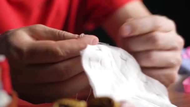 家の中で夜に白い綿の布から若い男が縫う 再利用可能な保護マスクを作成します 男の手のクローズアップビュー タイムラプス高速映像 — ストック動画