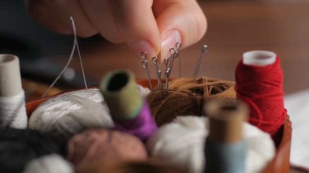 재단사는 직장에서 수있는 마스크를 만드는 바느질용 핀으로 조각을 실에서 채취하는 — 비디오