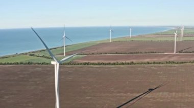 Dönen Rüzgar Türbinleri Bahar Manzarası. Yeşil Ekolojik Enerji Üretimi. Rüzgar Türbinleri Çiftliği Eko Alanı. Yel değirmenleri sahada. Hava görüntüsü. Enerji Üretimi.