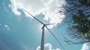 Bir rüzgar çiftliği ve elektrik üretimi için bir rüzgar türbini. Yavaşça dönen bıçaklı rüzgâr türbinleri. Yeşil güç