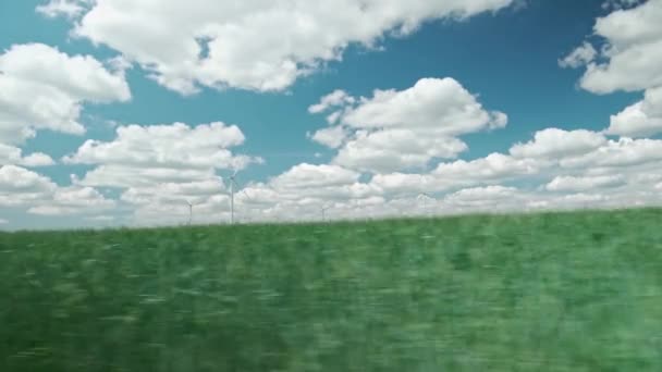 Ездить по сельской местности вдоль зеленых полей и ветряных турбин. Вид из окна автомобиля — стоковое видео