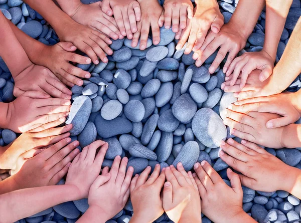 Un sacco di mani di bambini in cerchio sulle pietre . — Foto Stock