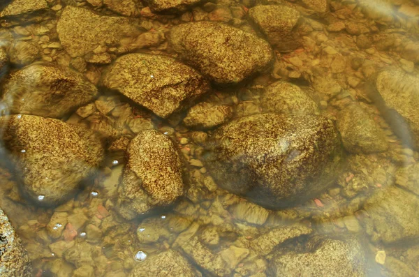 Las rocas yacen bajo el agua . —  Fotos de Stock