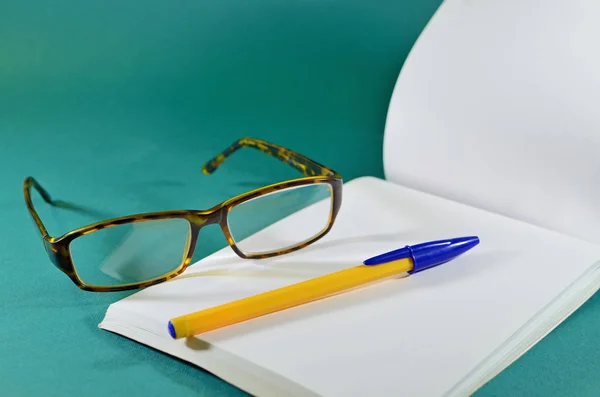 Beyaz gözlük ve kalem Notepad.On. — Stok fotoğraf