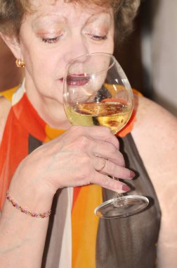 Bir kadın bir kadeh şarap elinde tutar..