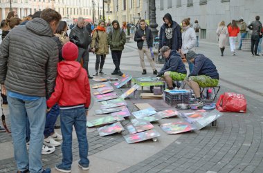 Artists paint with aerosol paints.