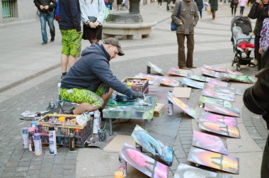 Artists paint with aerosol paints.