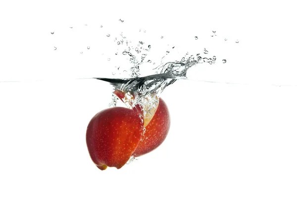 Frutas rojas de manzana haciendo salpicaduras en el agua —  Fotos de Stock