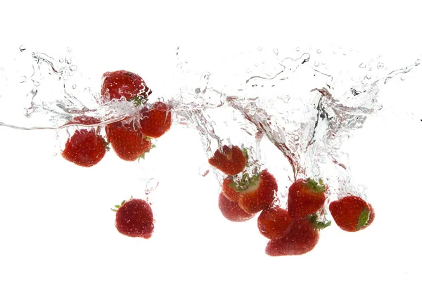 Frutos de morango fazendo respingo na água — Fotografia de Stock