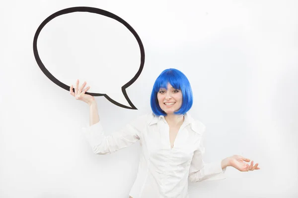 Pretty young brunette caucasian woman smiling with comic baloon and blue wig on white background — Stock Photo, Image