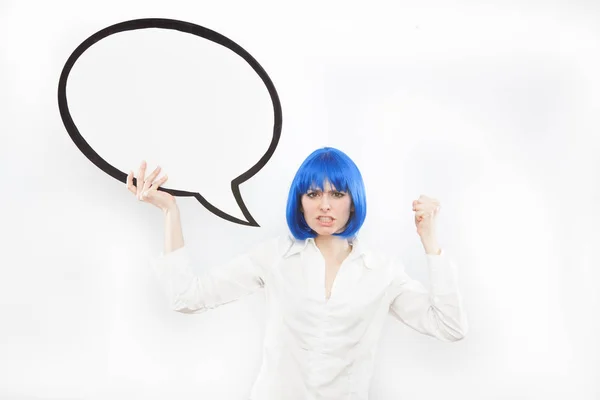 Pretty young brunette caucasian angry woman with comic baloon and blue wig on white background — Stock Photo, Image