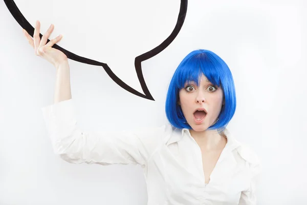 Jolie jeune femme caucasienne brune surprise avec un ballon comique et une perruque bleue sur fond blanc — Photo