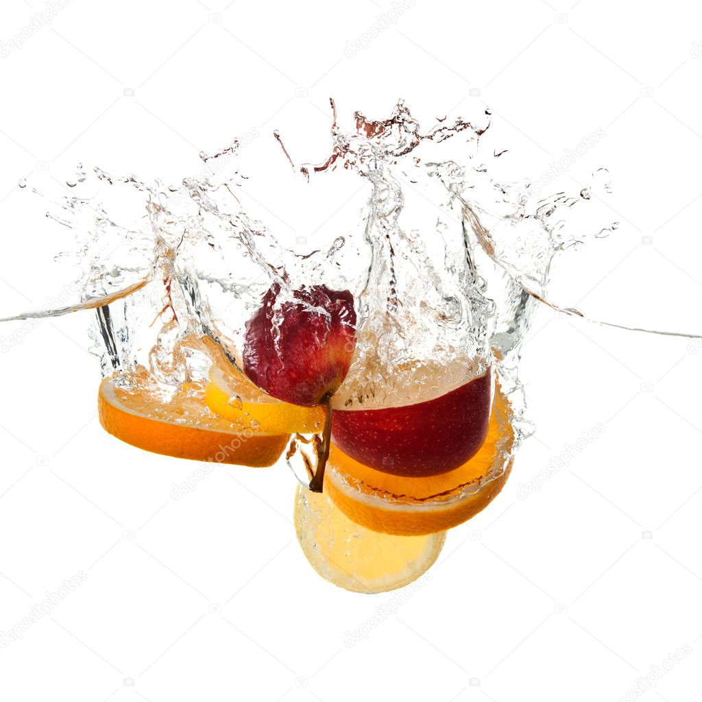 apple and orange fruits making splash in water