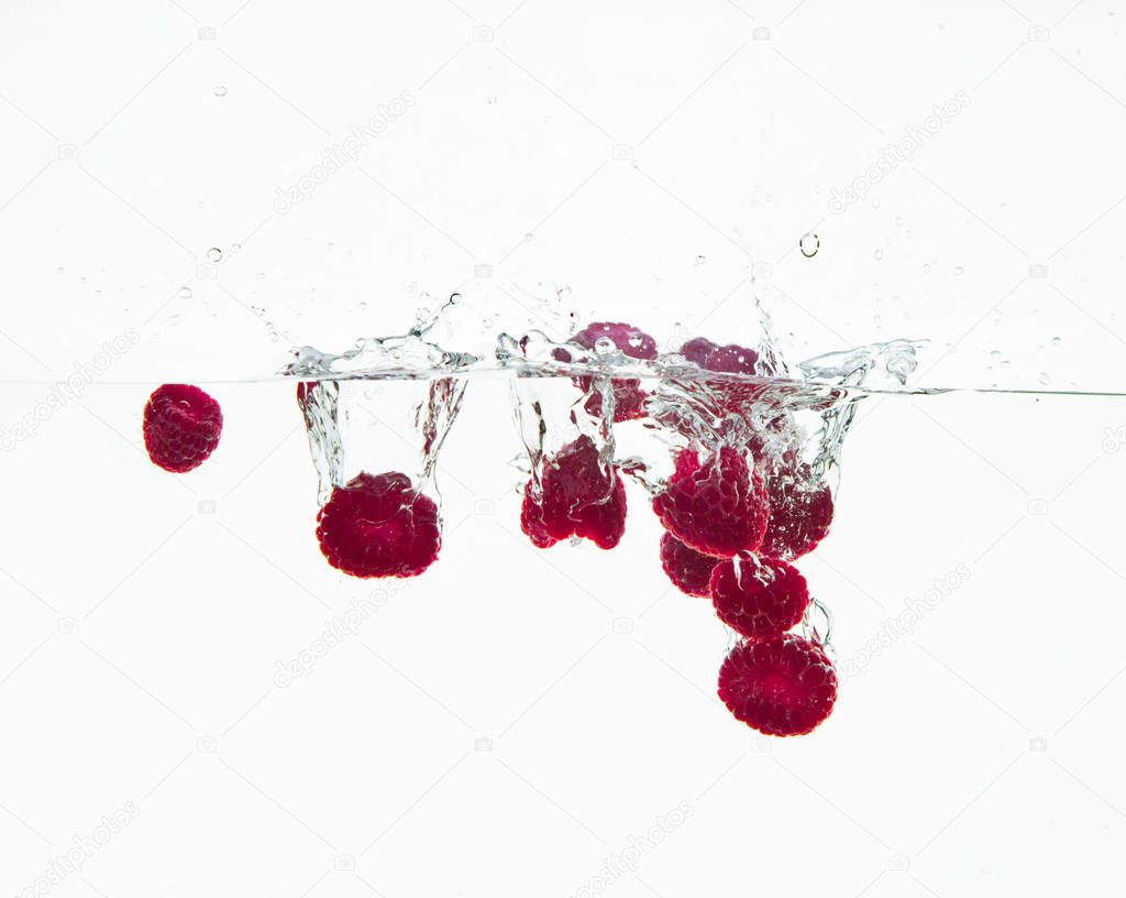 raspberry fruits making splash in water