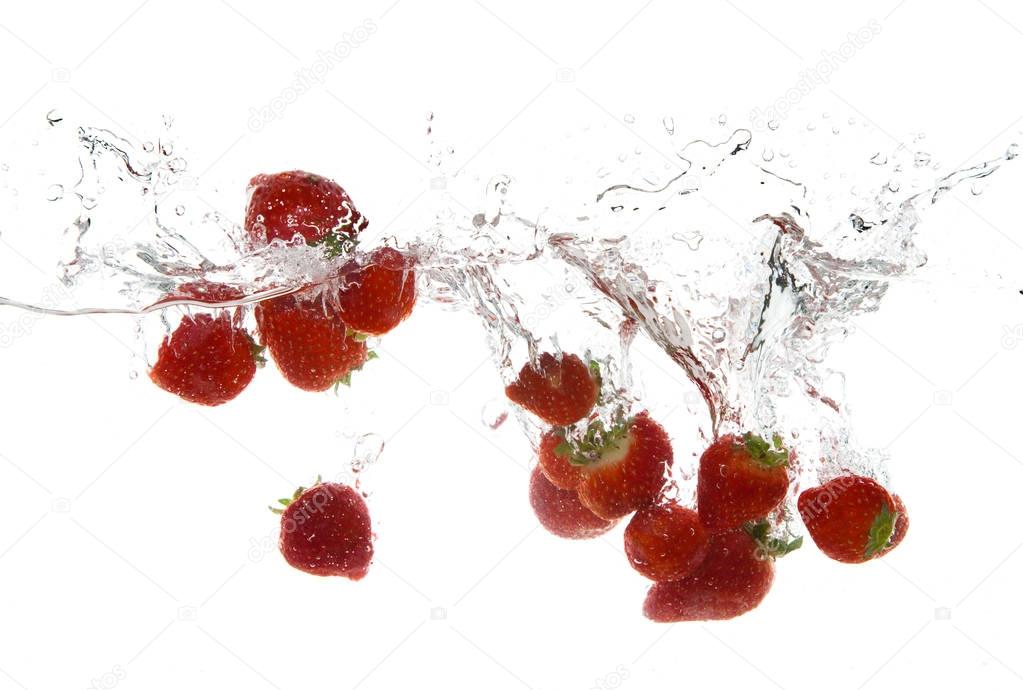 strawberry fruits making splash in water