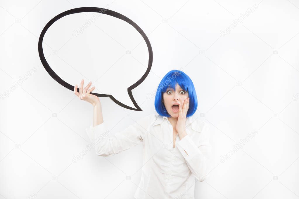 pretty young brunette caucasian woman surprised with comic baloon and blue wig on white background