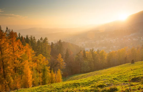 autumn landscape with town at sunset