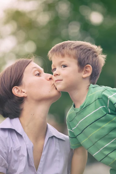 Счастливый белокурый белый ребенок открытый семейный портрет в парке со своей мамой — стоковое фото