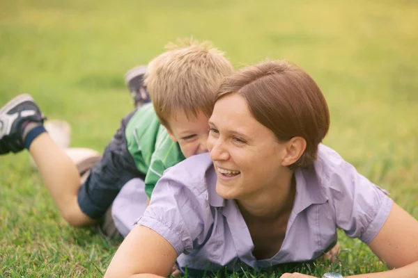 Happy blond caucasian kid outdoor family portrait at park with his mum — Stock Photo, Image