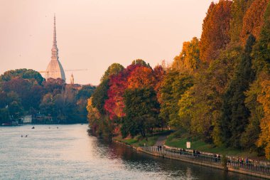 po river in turin city with mole antonelliana and people walking in part clipart
