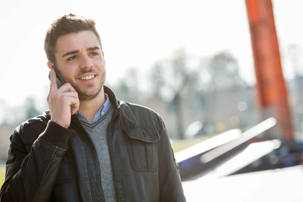 Casual uomo caucasico utilizzando smartphone in città urbana — Foto Stock