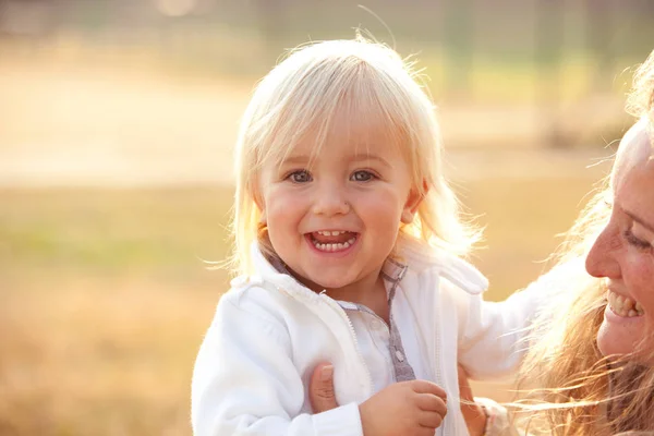 Blonde maman avec garçon fils jouer dans un parc — Photo