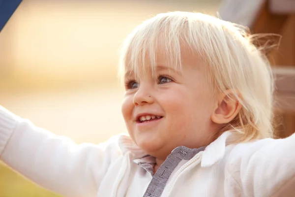 Blonde Kaukasische jongen glimlacht buiten in het park — Stockfoto