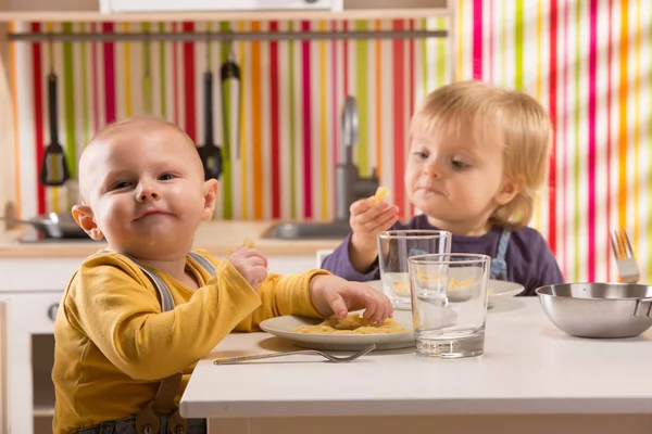 Família bebê irmão e irmã jogar comer refeição na cozinha de brinquedo — Fotografia de Stock