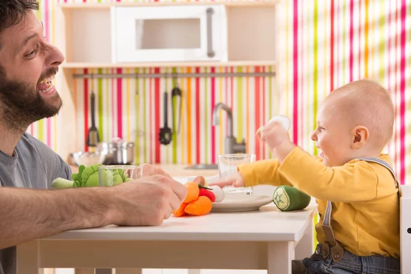 Aile bebek oğul ve baba oyun oyuncak mutfakta yemek yemek — Stok fotoğraf