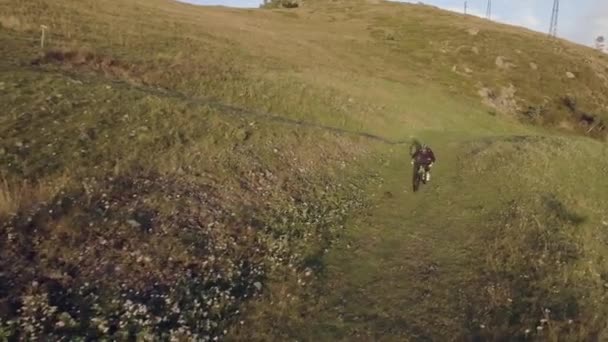 Passeio de trilha de motociclista no caminho offroad de bicicleta de montanha no dia ensolarado de verão, aproximando-se do pôr do sol ou amanhecer ou crepúsculo drone aéreo 4k volta voo médio tiro — Vídeo de Stock