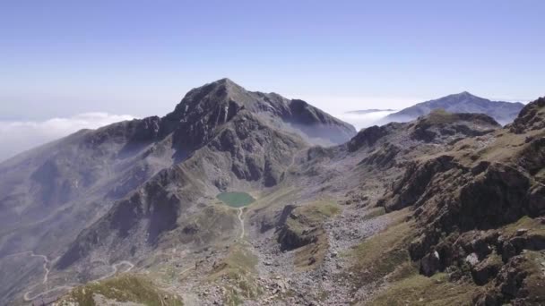 Italië Alpen bergen vanuit de lucht boven blue lake onthullen in zonnige zomerdag. 4 k drone terug vlucht breed vaststelling van schot — Stockvideo