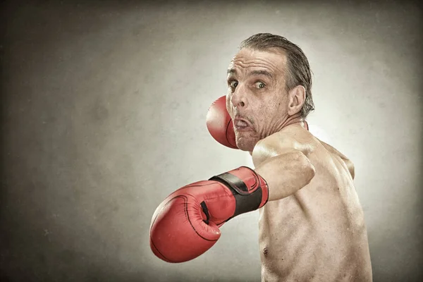 Homem boxeador sênior com luvas vermelhas retrato velho no fundo texturizado — Fotografia de Stock