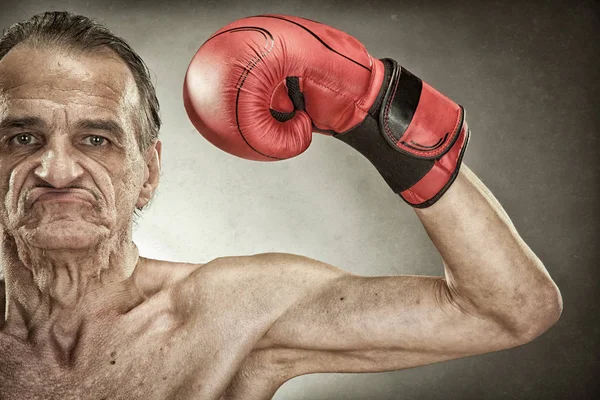 Homem boxeador sênior com luvas vermelhas retrato velho no fundo texturizado — Fotografia de Stock