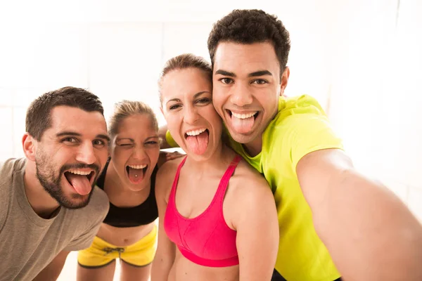 Sekelompok pemuda sporty membuat selfie dengan smartphone di gym — Stok Foto