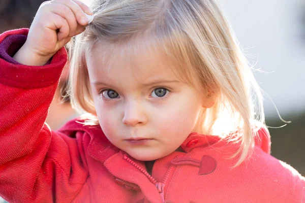 Ernstige denken of verdrietig jonge baby Kaukasische blond echte mensen meisje nauwe portret buiten — Stockfoto