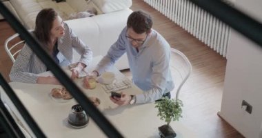 Genç çift İtalyan kapalı modern endüstriyel evde kahvaltı aşık. akıllı telefon kullanın. 4 k el üstten görünüm ek yükü video çekim