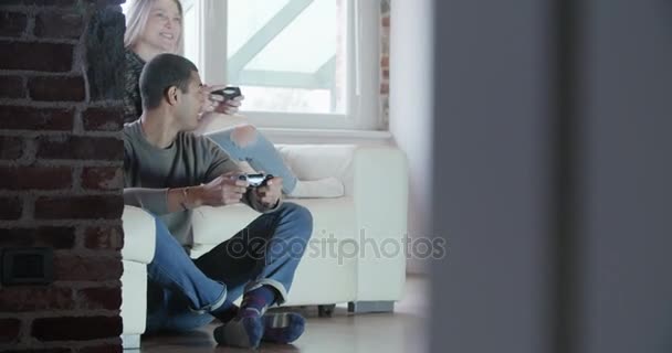 Grupo multiétnico de amigos as pessoas gostam de relaxar no sofá jogando videogames e se divertindo dentro de casa industrial moderna. 4k tiro de vídeo portátil — Vídeo de Stock