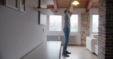 genç siyah adam akıllı telefon kulaklık ile müzik dinlemek ve modern endüstriyel evde kapalı dans rahatlatıcı. 4 k el ağır çekim video çekim