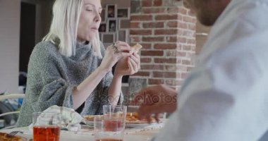 çok ırklı bir grup arkadaş insan zevk birlikte pizza kapalı modern endüstriyel evde yemek öğle veya akşam yemeği yemek. 4 k el ağır çekim video çekim