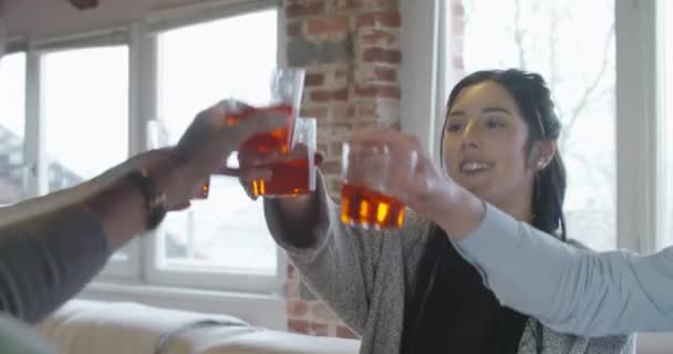 Grupo multiétnico de amigos personas disfrutan almorzar o cenar juntos comer pizza y tostadas en el interior de la casa industrial moderna. 4k toma de vídeo portátil — Vídeo de stock