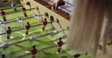 Masa futbolu oynayan arkadaş grubu. modern endüstriyel evde kapalı. Beyaz. 4 k el yavaş hareket ayrıntısı video çekim