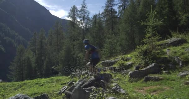 Corredor de senderos caucásicos corriendo en la montaña a través de bosques, pueblos. 4k gimbal amplio espalda vídeo disparo — Vídeos de Stock